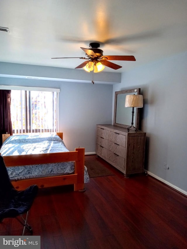 bedroom featuring ceiling fan, wood finished floors, visible vents, and baseboards