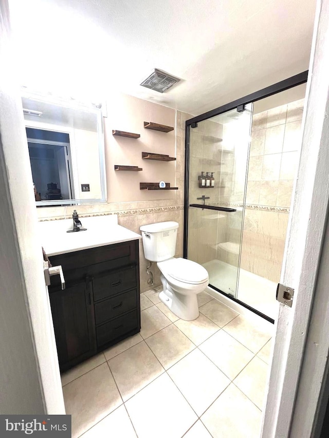 full bath featuring a shower stall, visible vents, tile walls, and tile patterned floors