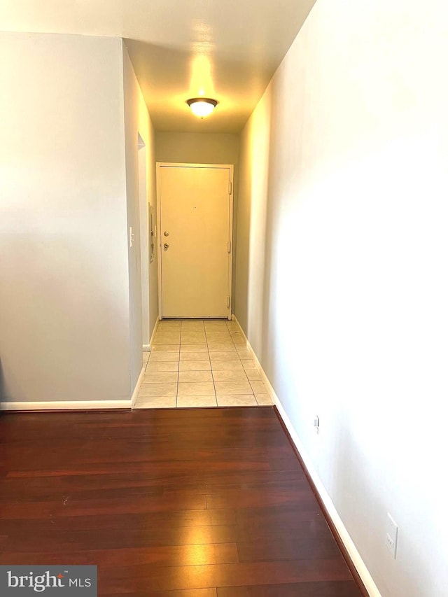 hallway featuring light wood-type flooring and baseboards