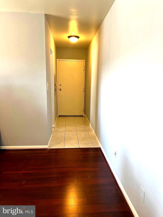 corridor with light wood-style floors and baseboards