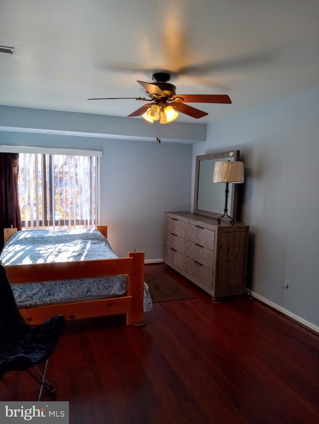 bedroom featuring baseboards, visible vents, ceiling fan, and wood finished floors