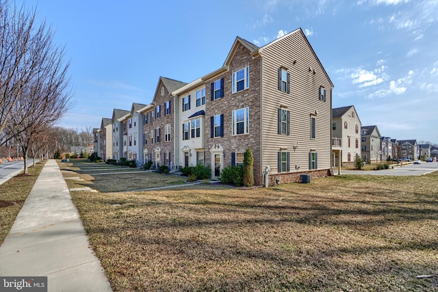 view of side of home with a lawn and a residential view