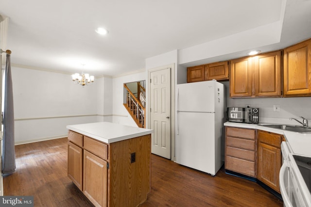 kitchen with a kitchen island, a sink, freestanding refrigerator, dark wood finished floors, and crown molding