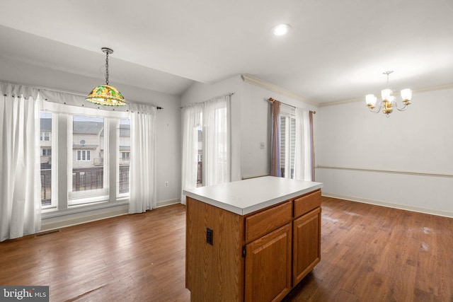 kitchen featuring hanging light fixtures, a kitchen island, wood finished floors, and light countertops