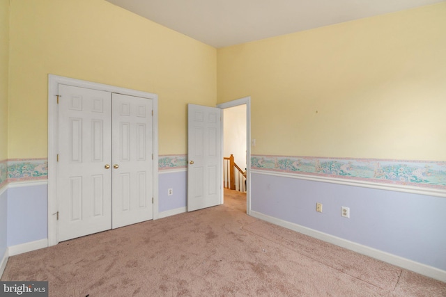 unfurnished bedroom with carpet, baseboards, and a closet