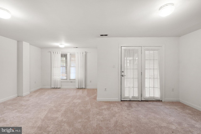 carpeted spare room featuring visible vents and baseboards