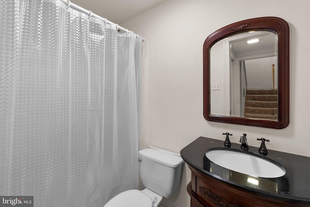 full bathroom featuring curtained shower, vanity, and toilet