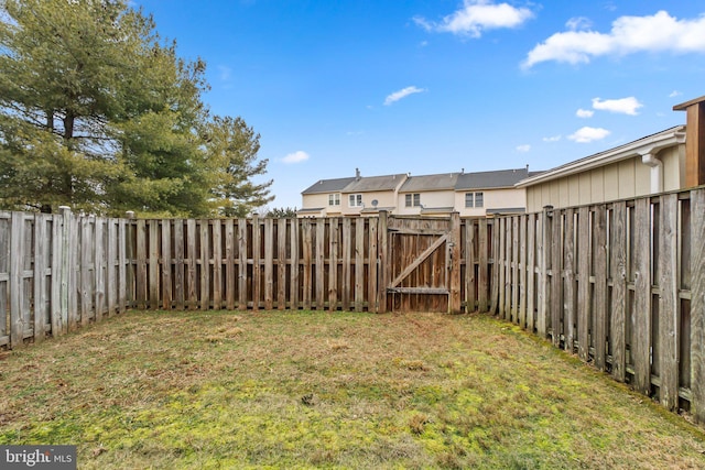 view of yard featuring a fenced backyard and a gate