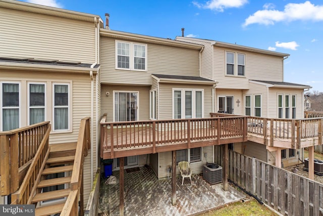 rear view of house with a deck, fence, and central air condition unit