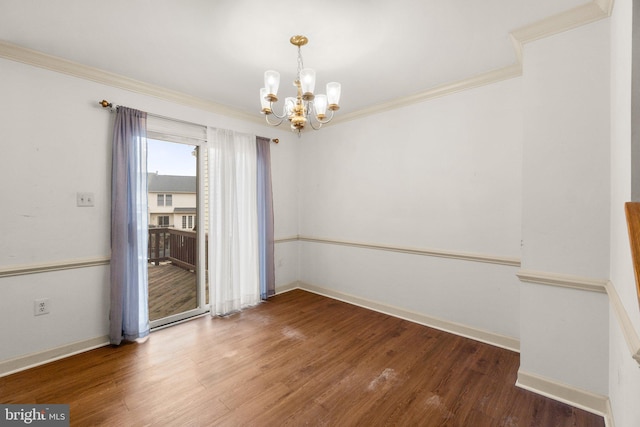 unfurnished room with baseboards, ornamental molding, a chandelier, and wood finished floors