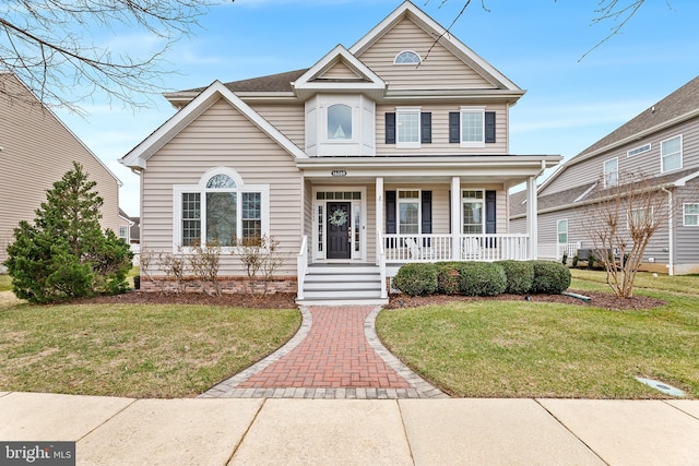 view of front facade with a front yard and covered porch