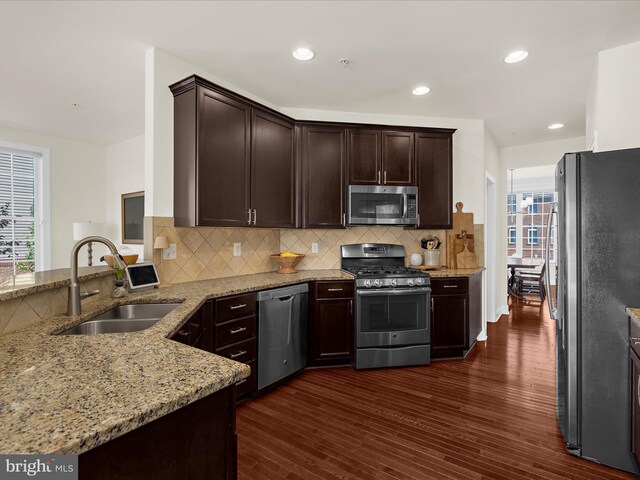 8512 Pine Springs Dr, Severn, MD 21144 - kitchen featuring stainless steel appliances, a sink, light stone counters, dark wood-style floors, and recessed lighting