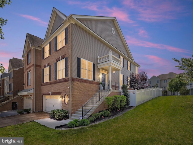 8512 Pine Springs Dr, Severn, MD 21144 - property exterior at dusk with a garage, a balcony, driveway, brick siding, and stairs