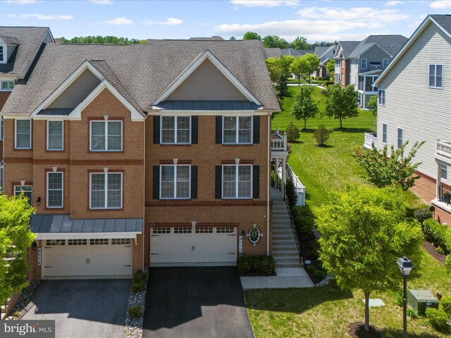 8512 Pine Springs Dr, Severn, MD 21144 - view of property featuring asphalt driveway, a standing seam roof, a garage, brick siding, and stairs