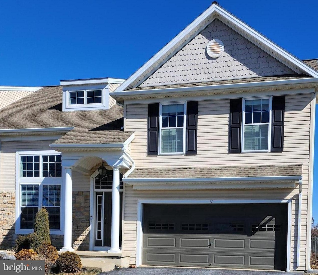 view of front of property with a shingled roof and an attached garage