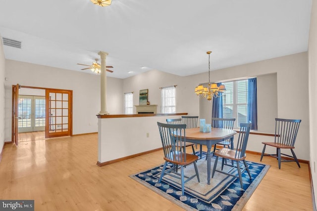 dining room with french doors, a fireplace, visible vents, light wood-style flooring, and baseboards