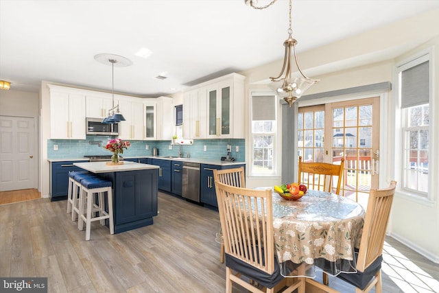 kitchen featuring blue cabinets, appliances with stainless steel finishes, a sink, and light countertops