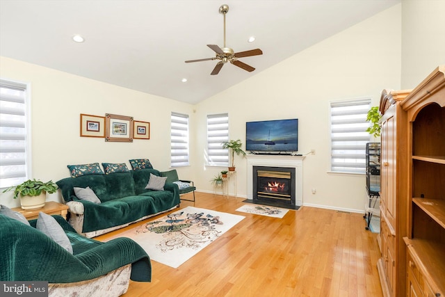 living room featuring ceiling fan, a fireplace with flush hearth, wood finished floors, and recessed lighting