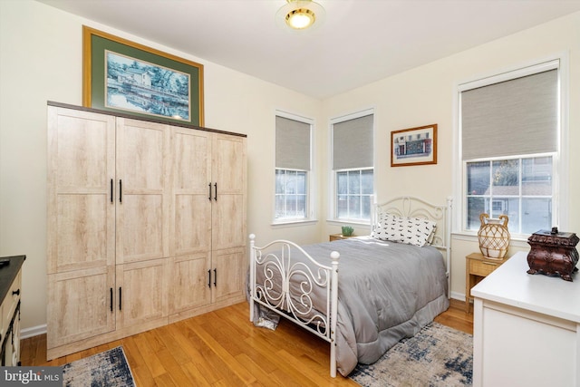 bedroom with light wood-style floors and baseboards