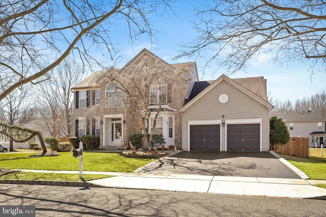 view of front facade featuring an attached garage, driveway, a front yard, and fence