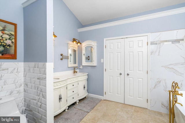 bathroom featuring double vanity, toilet, ornamental molding, and a sink