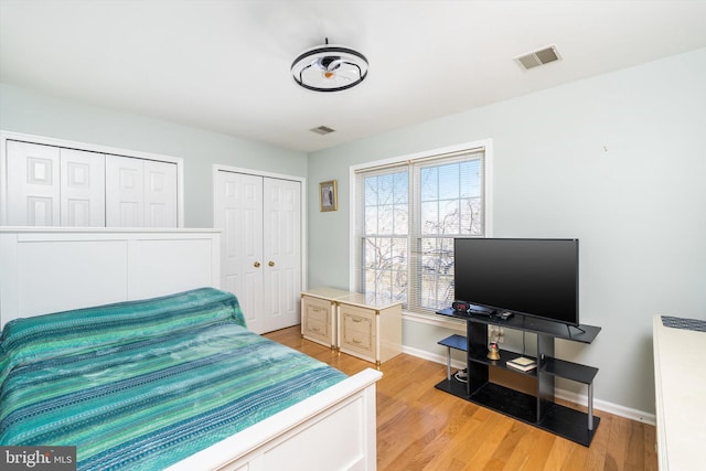 bedroom featuring visible vents, baseboards, and light wood-style floors