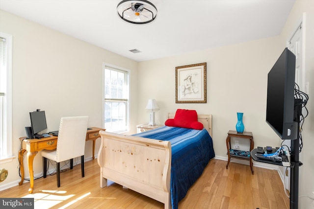 bedroom with visible vents, light wood-style flooring, and baseboards