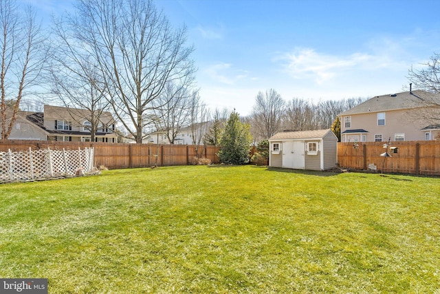 view of yard featuring a storage shed, an outbuilding, and a fenced backyard