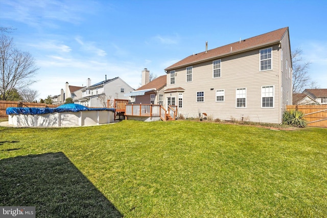 back of house with a yard, a fenced in pool, a deck, and fence