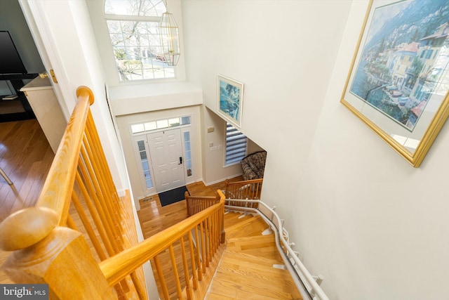 entryway with stairway, a high ceiling, wood finished floors, and baseboards