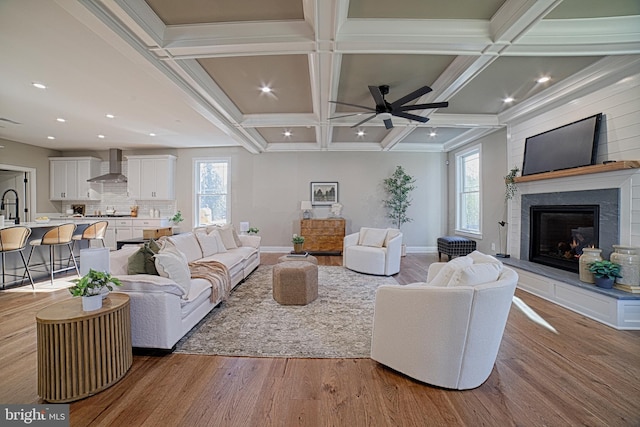 living room featuring beam ceiling, recessed lighting, a large fireplace, wood finished floors, and coffered ceiling