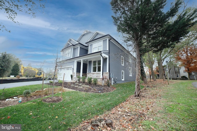 craftsman-style house with driveway, stone siding, an attached garage, a front lawn, and board and batten siding