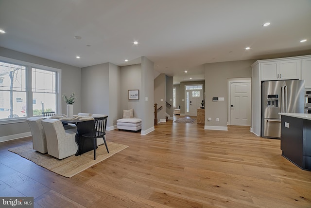 dining space with recessed lighting, baseboards, stairway, and light wood finished floors