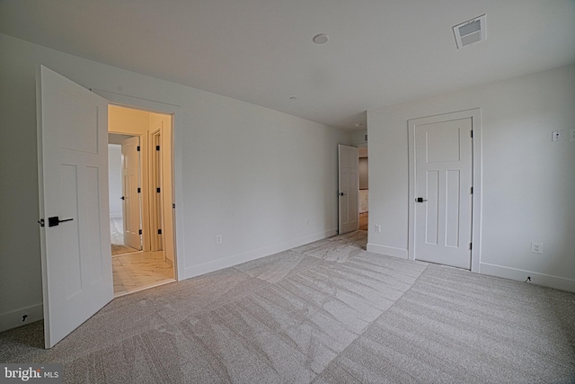 unfurnished bedroom featuring carpet flooring, visible vents, and baseboards