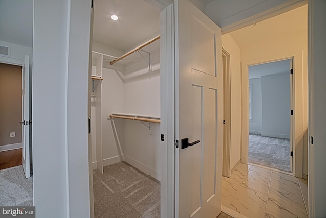 spacious closet with marble finish floor, visible vents, and light colored carpet