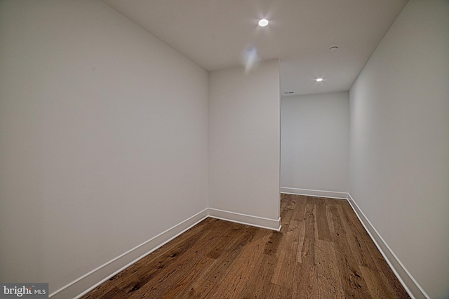 hallway featuring dark wood-style floors, baseboards, and recessed lighting