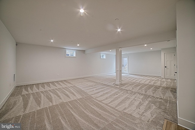 below grade area featuring light carpet, recessed lighting, visible vents, and baseboards