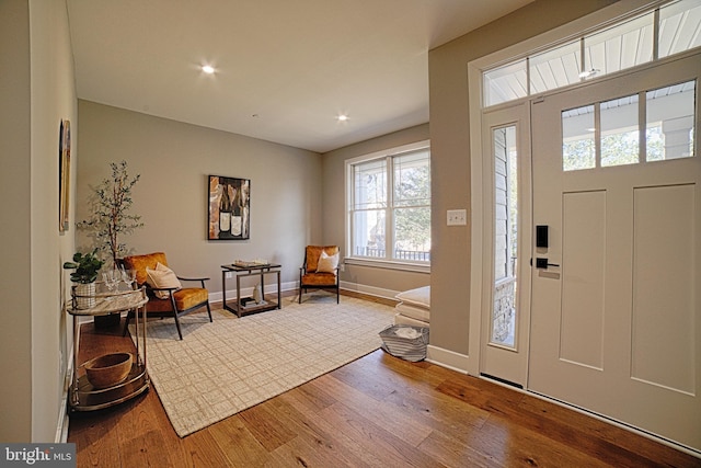 foyer featuring recessed lighting, wood-type flooring, and baseboards