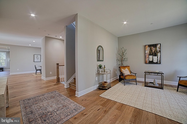 sitting room with baseboards, light wood finished floors, and recessed lighting