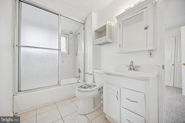 bathroom with toilet, combined bath / shower with glass door, tile patterned flooring, and vanity