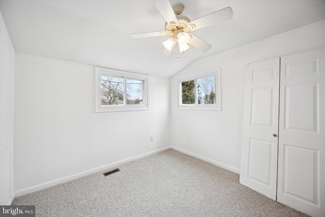 unfurnished bedroom with visible vents, baseboards, lofted ceiling, ceiling fan, and carpet flooring