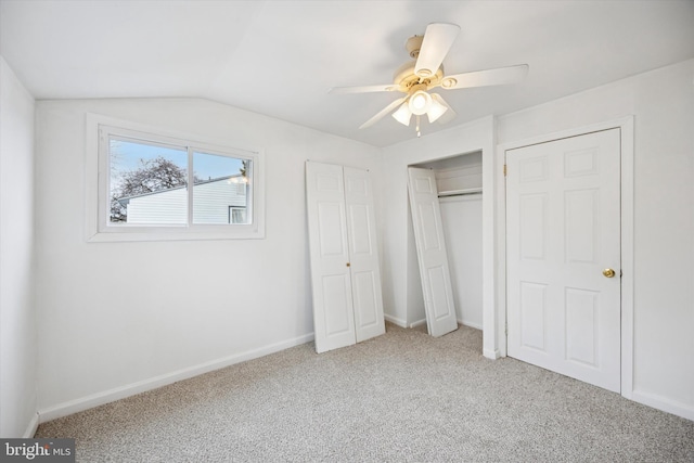 unfurnished bedroom featuring a ceiling fan, carpet, lofted ceiling, and baseboards