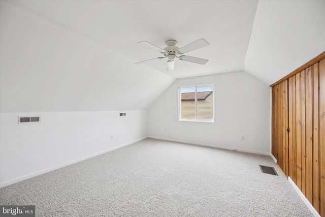 bonus room with light colored carpet, visible vents, vaulted ceiling, and baseboards