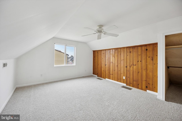 additional living space featuring carpet floors, visible vents, and vaulted ceiling