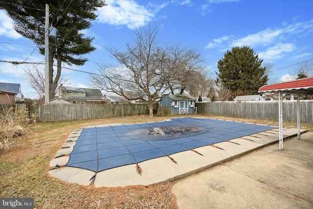 view of pool featuring a fenced in pool, an outbuilding, a patio area, a shed, and a fenced backyard