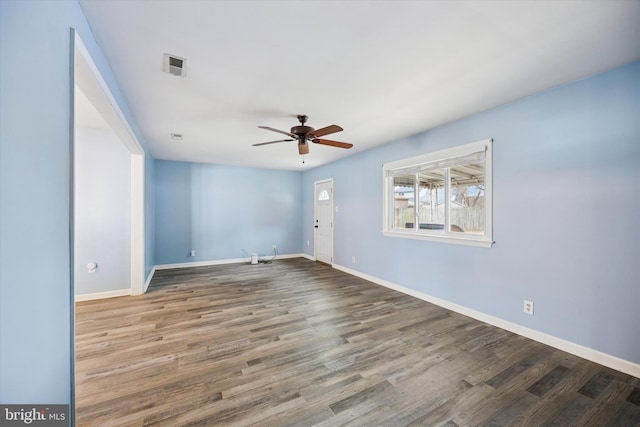 spare room with visible vents, ceiling fan, baseboards, and wood finished floors