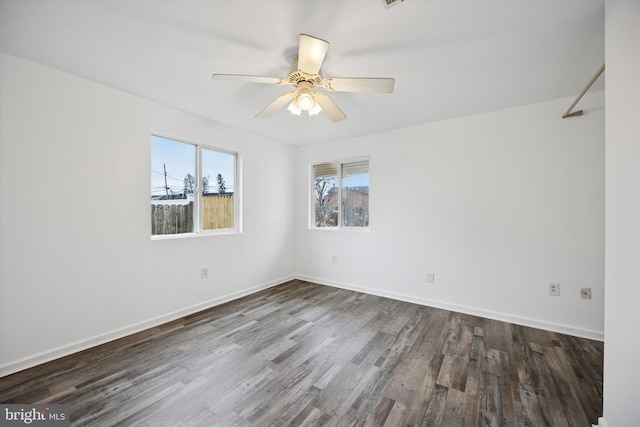 empty room featuring a ceiling fan, baseboards, and wood finished floors