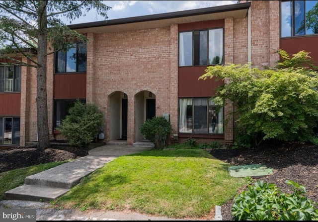view of front of home featuring a front lawn and brick siding