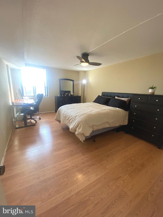 bedroom featuring light wood-style flooring, baseboards, and a ceiling fan