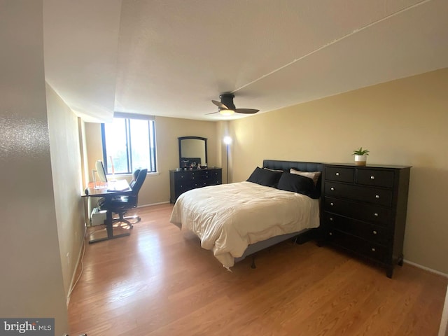 bedroom with baseboards, ceiling fan, and light wood-style floors